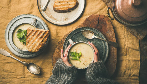 istock Celery cream soup, grilled bread and female hands 1059972022