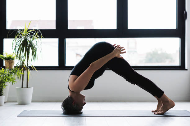 istock Middle aged woman doing yoga indoors 1059974842