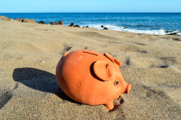 istock Piggy Bank on the Sand Beach 1059978366