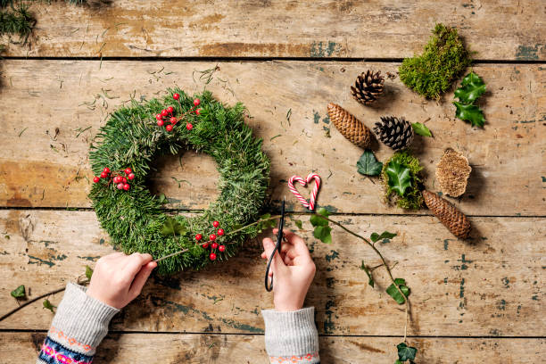 istock Overhead view of Christmas wreaths being made. 1059999096