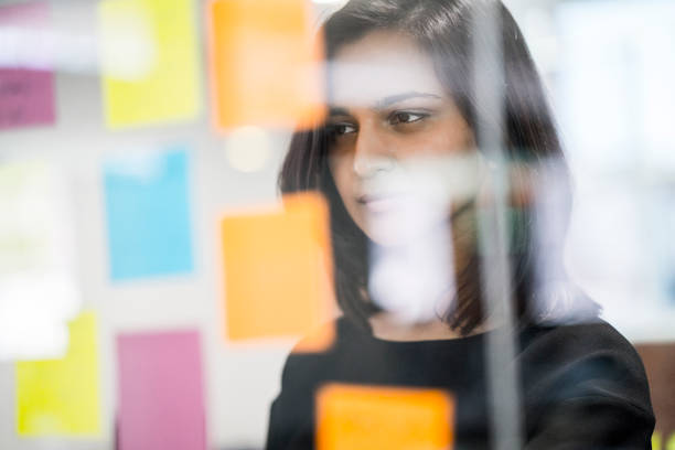 istock Businesswoman reading adhesive notes on glass 1060002696