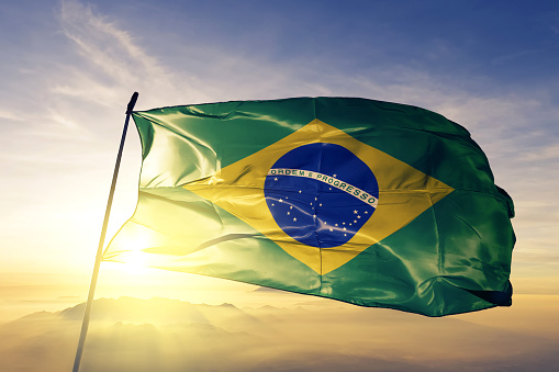 Brasil bandera brasileña textil tela de tela ondeando en la niebla de la niebla de amanecer superior photo