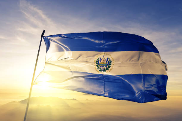сальвадорский флаг текстильной ткани ткань размахивая на вершине туман восхода солнца - salvadoran flag стоковые фото и изображения