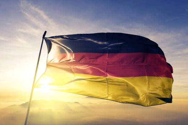 niemcy niemiecka flaga tkaniny tekstylnej tkaniny macha na górze mgła wschód słońca - germany zdjęcia i obrazy z banku zdjęć