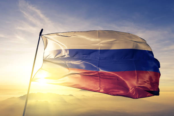 俄羅斯國旗紡織布面料在日出薄霧頂部揮舞 - 俄羅斯 個照片及圖片檔
