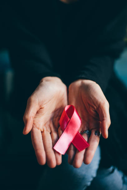 frau hände geben rosa satinband - breast cancer breast cancer awareness ribbon social awareness symbol human hand stock-fotos und bilder