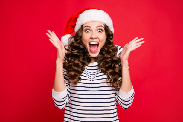 Merry holly x mas portrait of crazy cool cheerful glad positive optimistic charming curly-haired girl in casual striped pullover clapping palms waiting for gift isolated over red background Merry holly x mas portrait of crazy cool cheerful glad positive optimistic charming curly-haired girl in casual striped pullover clapping palms waiting for gift isolated over red background christmas excitement stock pictures, royalty-free photos & images