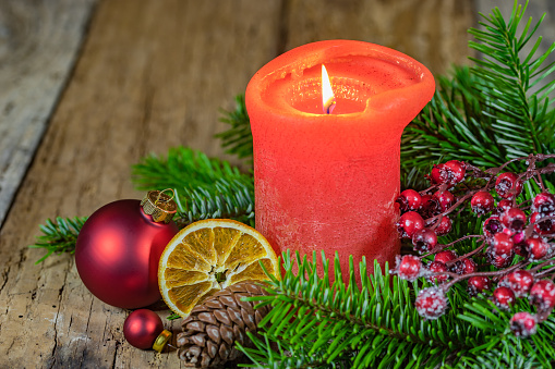 Advent and Christmas time candlelight with green and traditional decoration on wooden table