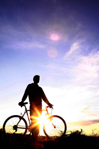istock Man with bicycle at dawn 4 1060015660