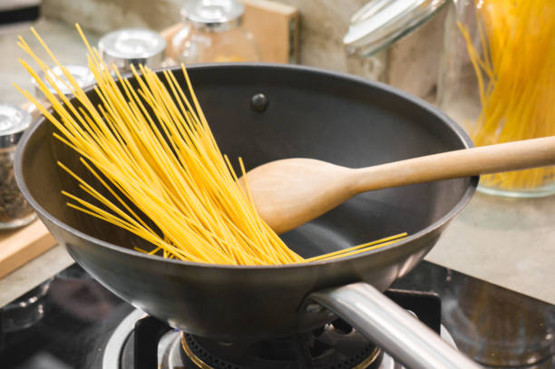 istock Raw spaghetti in pan ready for cooking in kitchen by chef 1060018236
