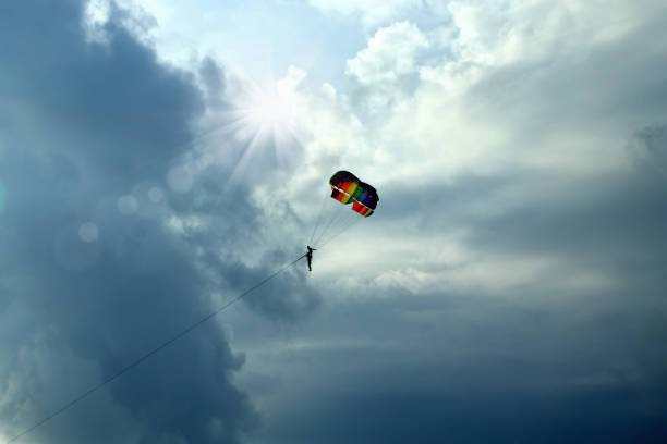 istock parasailing fun with colorful parachute over storm clouds 1060024920