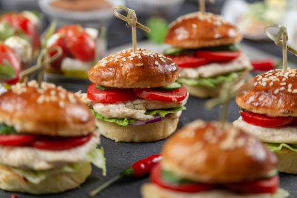 Set of chicken burgers on black board on wooden table stock photo