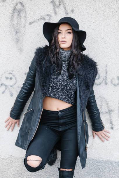 istock Young beautiful woman standing in front a wall wearing trendy fall outfit. 1060035236