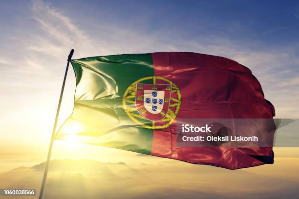 Португалия Португальский Флаг Текстильной Ткани Ткань Размахивая На Вершине Туман Восхода Солнца Туман — стоковые фотографии и другие картинки Португалия