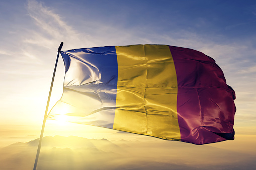 Rumania bandera rumana paño tela ondeando en la niebla de la niebla de amanecer superior photo