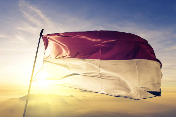 インドネシアとモナコ インドネシア旗布織物トップ日の出霧霧に手を振る - インドネシア国旗 ストックフォトと画像