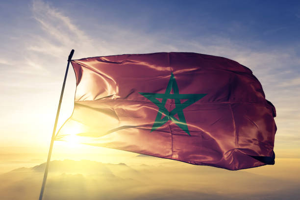 モロッコ モロッコ旗布織物トップ日の出霧霧に手を振る - moroccan flags ストックフォトと画像