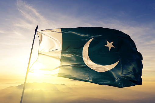 Pakistán Pakistán bandera tela tela ondeando en la niebla de la niebla de amanecer superior photo