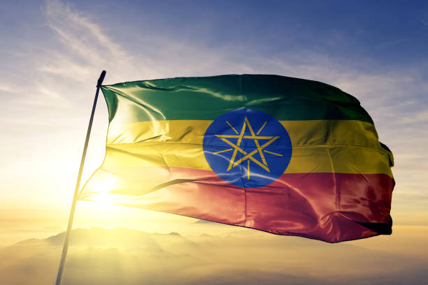 äthiopien äthiopischen flagge textil tuchgewebe winken auf der oberen sonnenaufgang nebel nebel - äthiopien stock-fotos und bilder