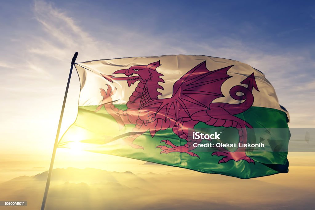 Wales Welsh United Kingdom Great Britain flag textile cloth fabric waving on the top sunrise mist fog Wales Welsh United Kingdom Great Britain flag on flagpole textile cloth fabric waving on the top sunrise mist fog Wales Stock Photo