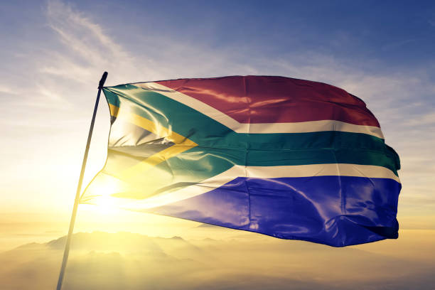 zuid-afrika-afrikaanse vlag textielweefsel doek zwaaien op de bovenste zonsopgang mist mist - zuid afrika stockfoto's en -beelden