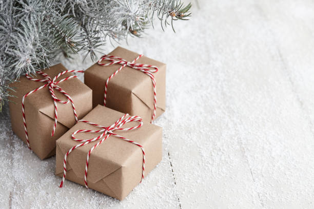 scatole regalo di natale avvolte in carta kraft sotto l'abete - snow bound foto e immagini stock