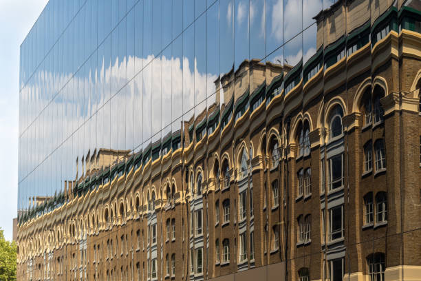 neu gegen alt - reflektiert einem alten backsteingebäude in windows der moderne neue fassade - brick wall old window brick stock-fotos und bilder