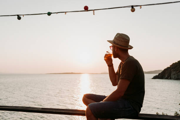 istock Man enjoying sunset by the sea 1060058500