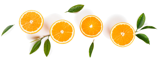 Halves of orange fruits and leaves with drops of water isolated on white background. Flat lay, top view.