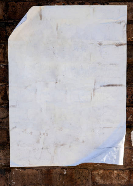 istock Old blank paper pasted on brick wall. 1060070110