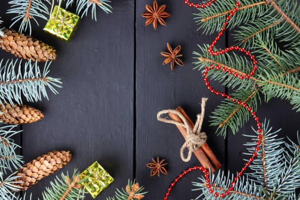 istock Christmas pattern with fir branches and pine cones. Cinnamon sticks, anise and fir branches on dark boards. Christmas branches, fir cones and red necklace on wooden boards 1060073464