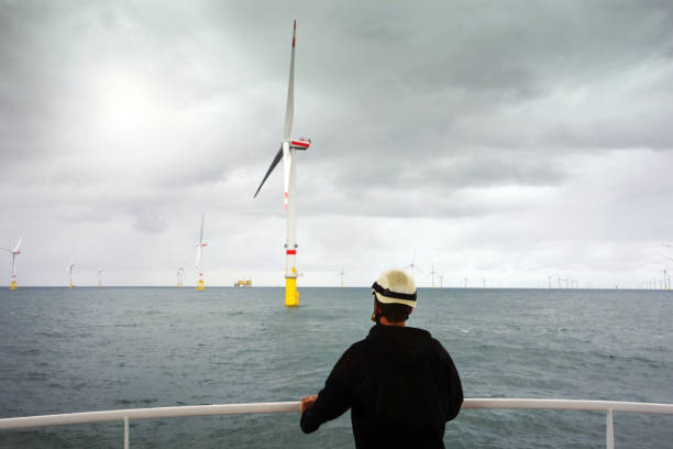 Manual worker offshore looking on wind-turbines wind farm from boat in North sea close to Borkum stock photo