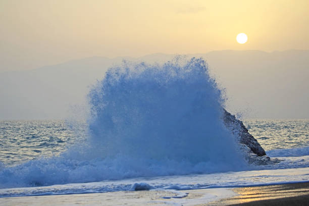 istock Sea wave beats on the rock against the sunset 1060076140