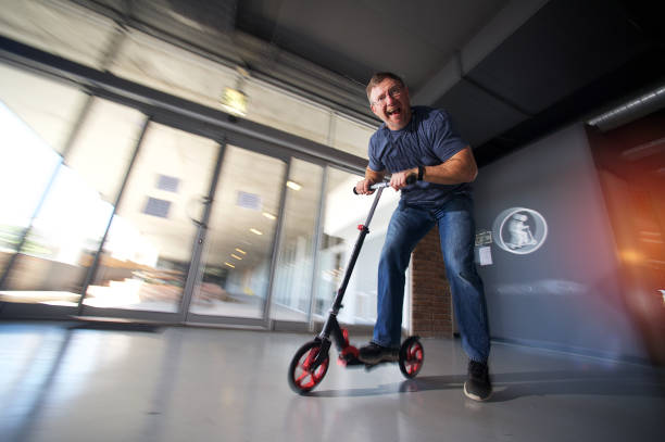 istock Push Scooter Businessman total fun in the office coming around corner 1060076640