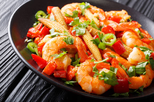 shrimp with bell pepper, chili, garlic, corn cob and herbs close-up on a plate. horizontal - mexico chili pepper bell pepper pepper imagens e fotografias de stock