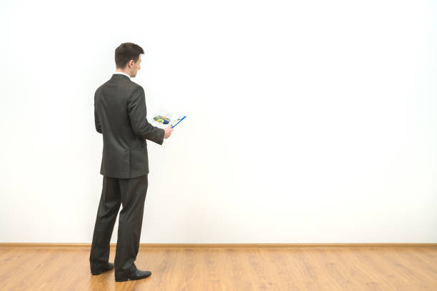 istock The businessman holds papers on the white wall background 1060081804