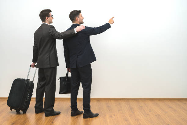 istock The two men with bags gesture on the white wall background 1060085894