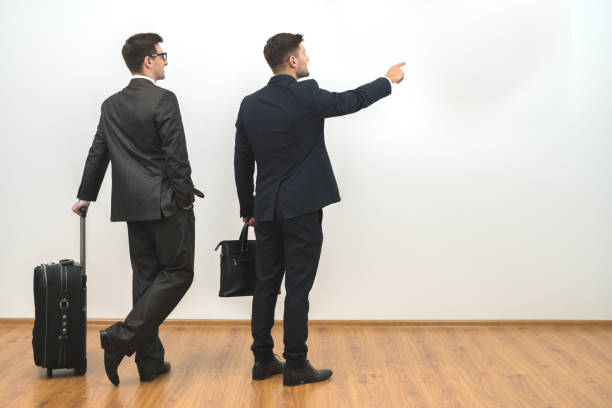 istock The two men with bags gesture on the white wall background 1060085928