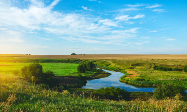 istock Sunny summer landscape with fields,river bend and beautiful woods. 1060095150