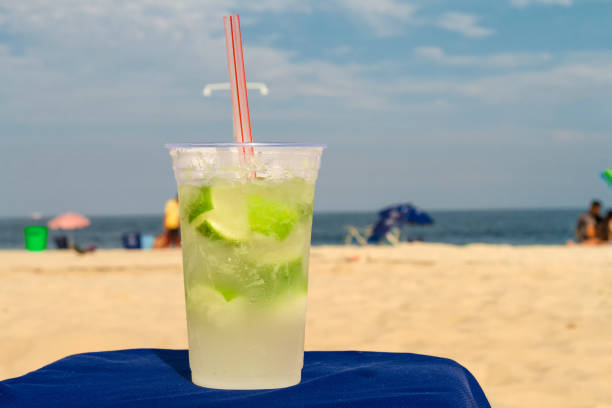 glas mit caipirinha auf dem strand von copacabana (rio de janeiro, brasilien) - rio de janeiro copacabana beach ipanema beach brazil stock-fotos und bilder