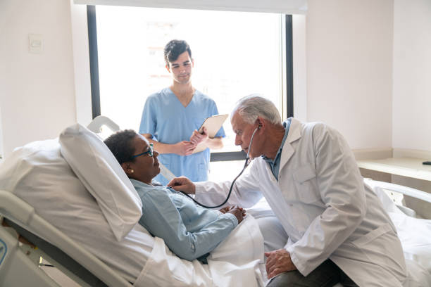 istock Cardiologist checking on black female hospitalized patient while nurse is standing next to them 1060112820