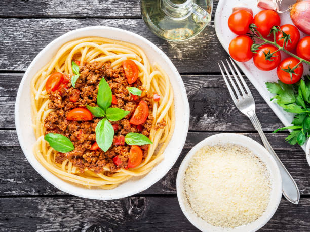 istock pasta bolognese with tomato sauce, ground minced beef, basil leaves on dark rustic wooden table, top view 1060120480