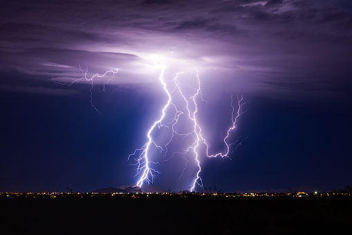 Lightning bolt storm with thunderstorm clouds at night.