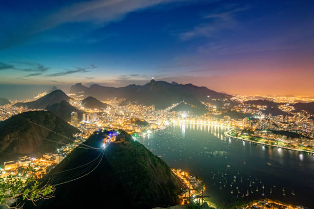 veduta aerea di rio de janeiro di notte con urca e corcovado e baia di guanabara - rio de janeiro, brasile - rio de janeiro night sugarloaf mountain corcovado foto e immagini stock