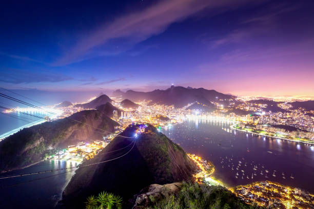 veduta aerea di rio de janeiro di notte con urca e corcovado e baia di guanabara - rio de janeiro, brasile - rio de janeiro night sugarloaf mountain corcovado foto e immagini stock