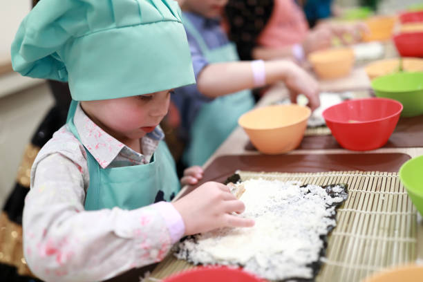 istock Child putting sushi ingredients 1060130230