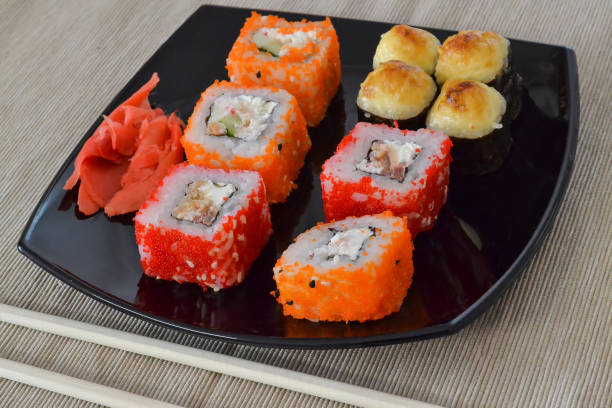 istock Sushi and rolls on a black plate with chopsticks. 1060139638