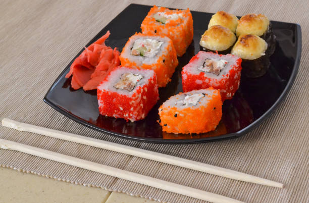 istock Sushi and rolls on a black plate with chopsticks. 1060139706