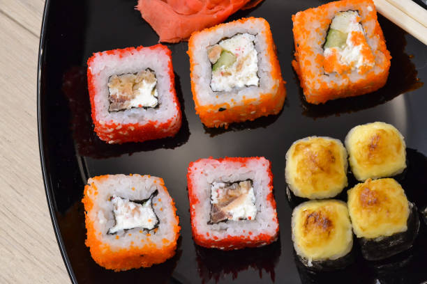 istock Sushi and rolls on a black plate with chopsticks. top view 1060139742