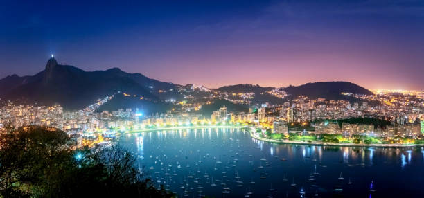 panoramische luftaufnahme von rio de janeiro und guanabara-bucht mit corcovado berg in der nacht - rio de janeiro, brasilien - rio de janeiro sugarloaf mountain beach urca stock-fotos und bilder